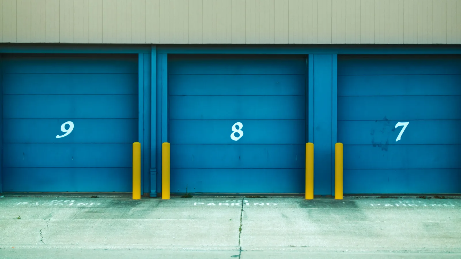 Three numbered blue roller-door storage units