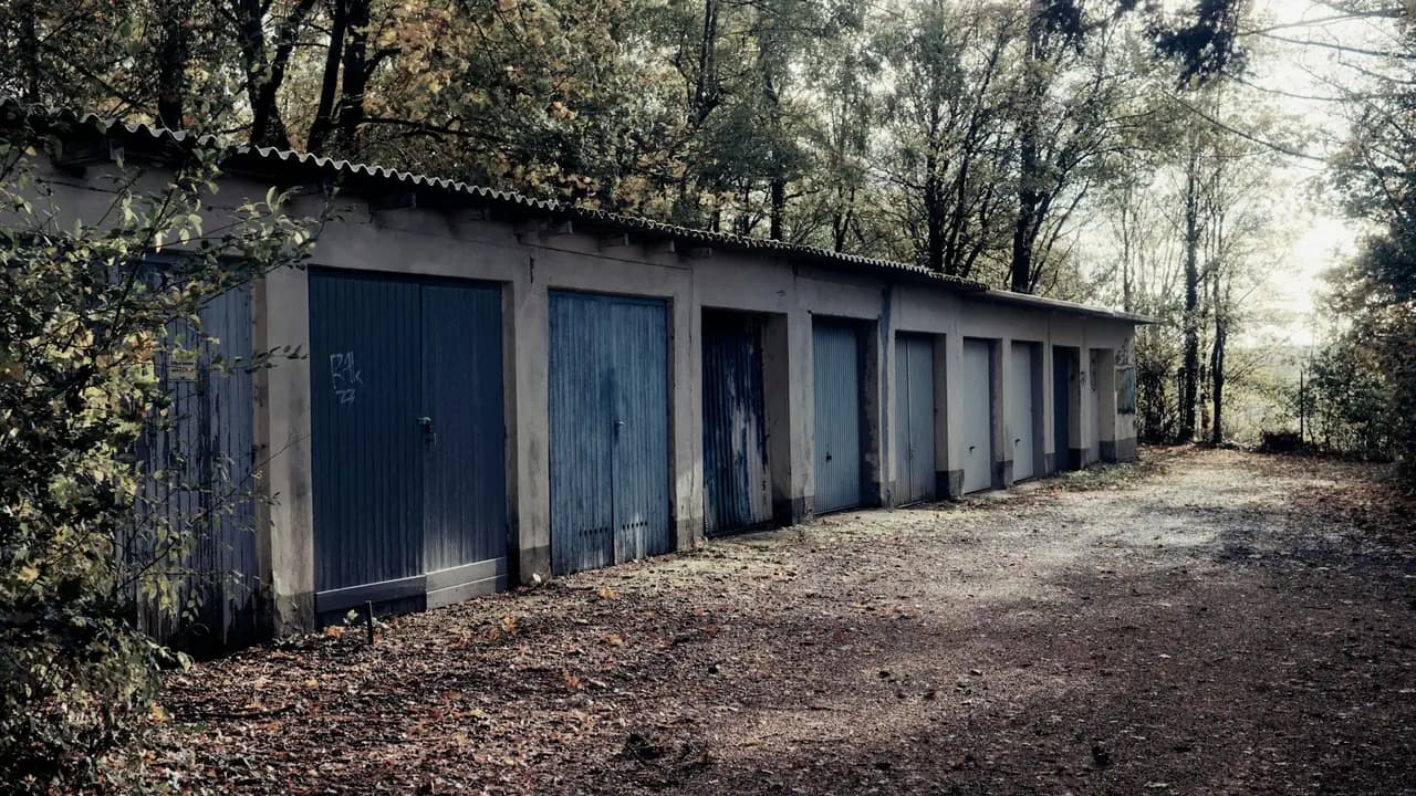 A row of lock-up garages on a gravel track